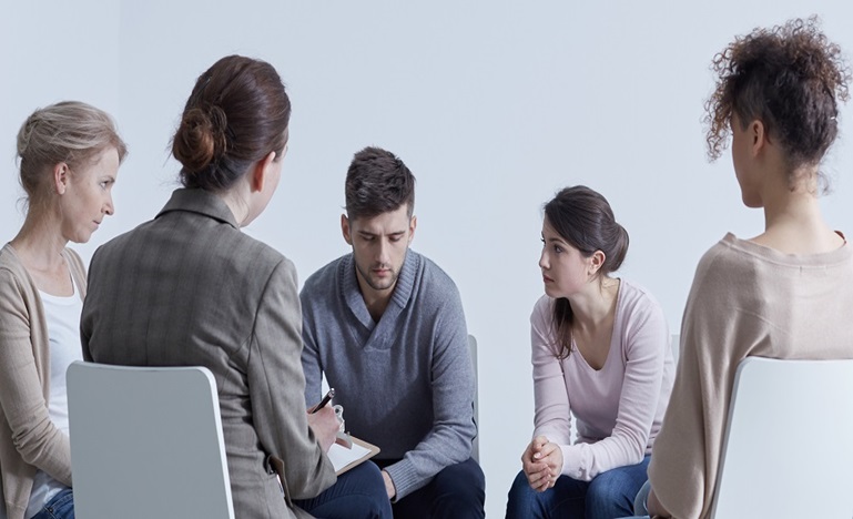 Three people sitting in circle in a support group