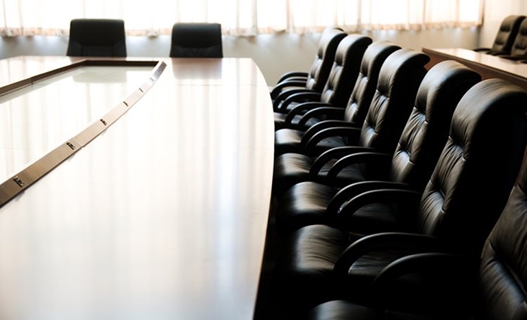 Row of padded chairs at a board table