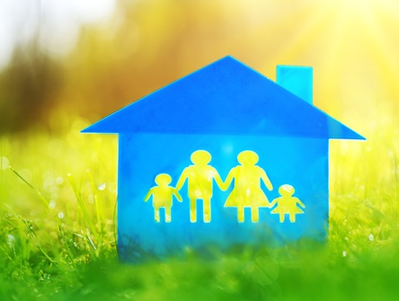 picture of blue house with silhouettes of four family members, two children and two adults, holding hands inside, all situated on a green-grass field