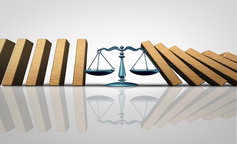 Scales of Justice between two rows of books falling like dominos