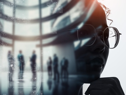 profile of a pensive young professional's face overlaid against a background featuring an office with a group of business people, and computer code superimposed
